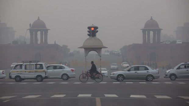 Vehicles move past the Presidential Palace as smog engulfs the evening in New Delhi in January.