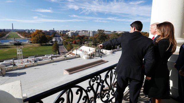 House Speaker Paul Ryan shows President-elect Donald Trump and his wife Melania the view of the inaugural stand that is being built and Pennsylvania Avenue from the Speaker's Balcony on Capitol Hill in Washington.