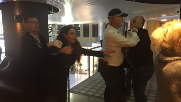 Michael Teplitsky, right, and his girlfriend, Olivia Korner, scuffle with police outside Rommark's offices.