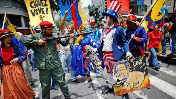 Government supporters perform a parody involving a Venezuelan militia up against Uncle Sam, a personification of the US government, during an anti-imperialist march to denounce Trump's talk of a "military option" in August.