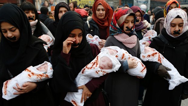 Foreign students in Bosnia hold toy dolls to symbolise dying infants of Aleppo during a solidarity rally in Sarajevo on Wednesday.