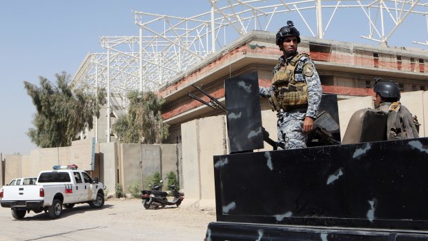 Iraqi security forces guard the entrance to a sports complex where 18 Turkish workers were abducted from in a Shiite district of Sadr City, Baghdad.