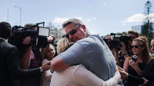 Peter and Rebecca McNeill hug after a jury found their son's killers guilty of his murder in October.