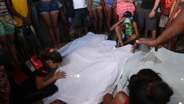 Relatives and friends gather next to bodies found at the Cidade de Deus slum in Rio de Janeiro on Sunday.
