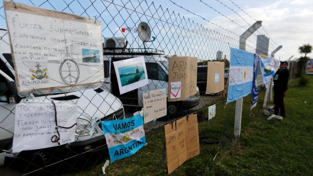 Signs with messages in support of the crew of the Argentine submarine ARA San Juan hang from the fence at the naval base after the vessel vanished last week.