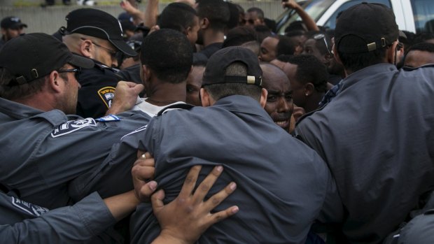 Israeli policemen push protesters, mainly Israeli Jews of Ethiopian origin, at a protest in Tel Aviv on Sunday.