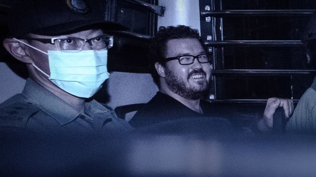 British banker Rurik Jutting, charged with the murders of two women, smiles as he sits in a prison van leaving the eastern court in Hong Kong. 