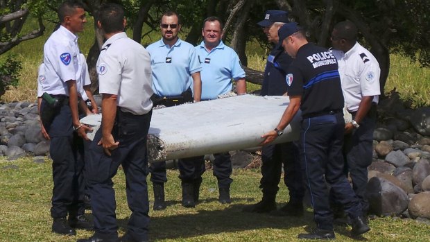 French officers carry the flaperon that has been confirmed as coming from a Boeing 777. 