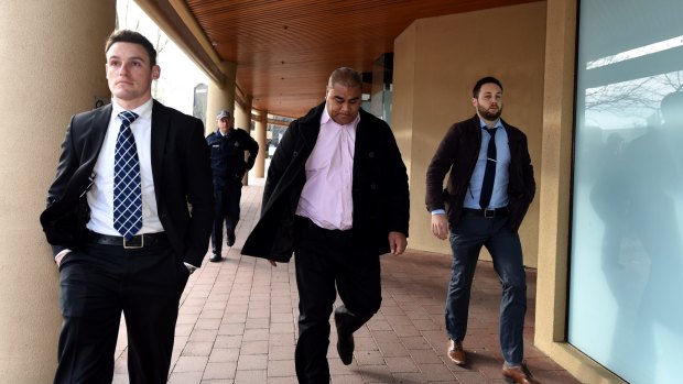 Former CFMEU official Halafihi "Fihi" Kivalu (centre) is taken into custody by plain clothed police after appearing at the Royal Commission into Trade Union Corruption hearing in Canberra.