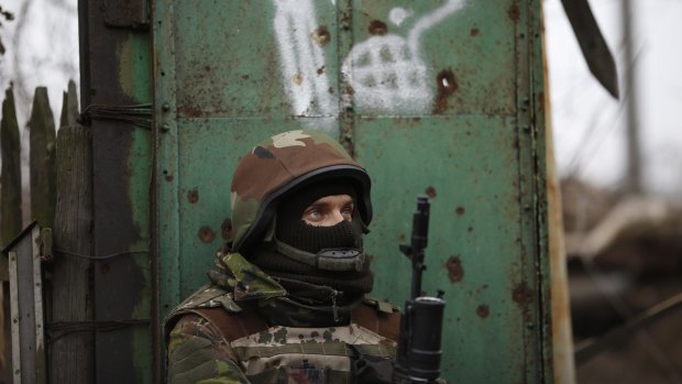A Ukrainian volunteer fighter stands guard in the village of Peski, near Donetsk.