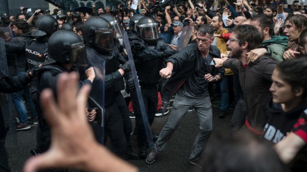 Catalans confront Spanish riot police near a voting site in Barcelona on polling day, October 1.