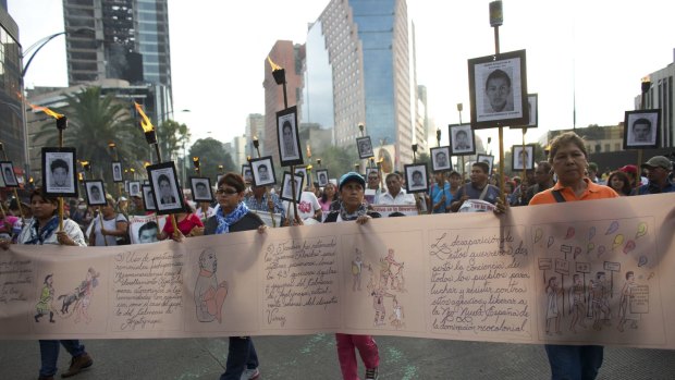 Supporters of the missing students march in Mexico City on Tuesday to demand the case not be closed and new leads be followed.