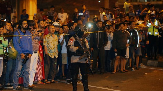 Police officers clear the scene after an explosion near a bus stop in the Kampung Melayu area of Jakarta.