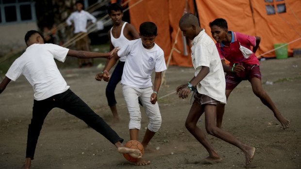 Ethnic Rohingya men play soccer near at  temporary shelter in Langsa, Aceh province, Indonesia on Friday.
