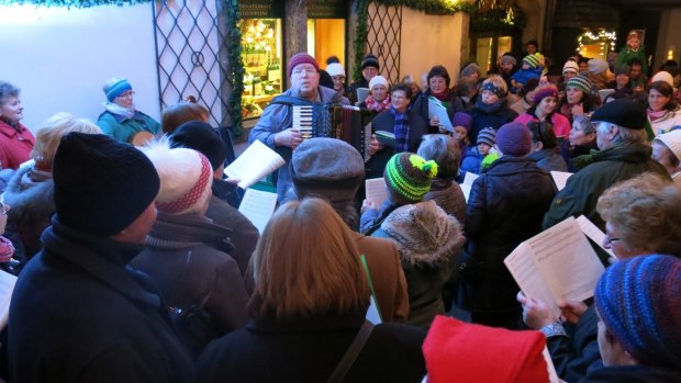 Good old singalong: Locals sing Christmas carols in the town square.