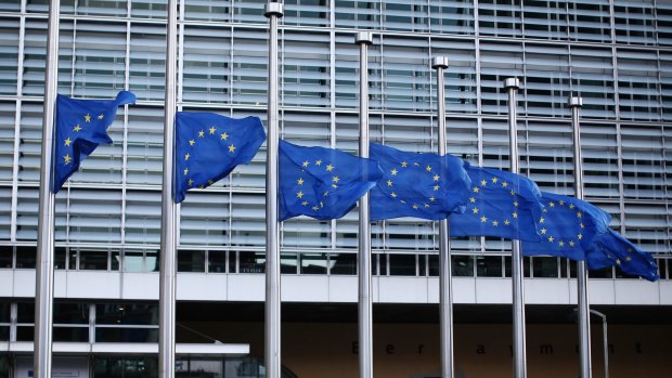 European Union flags flying outside EU Commission headquarters in Brussels. 