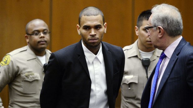 Dark days ... Singer Chris Brown appears in court with his attorney for a probation hearing in 2013 in Los Angeles. He was first given probation in 2009 after pleading guilty to assaulting his then-girlfriend Rihanna.