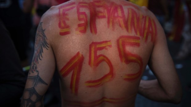 A shirtless man sports  the words "Spain" and "155" - in reference to the implementation of the article 155 in Catalonia region.