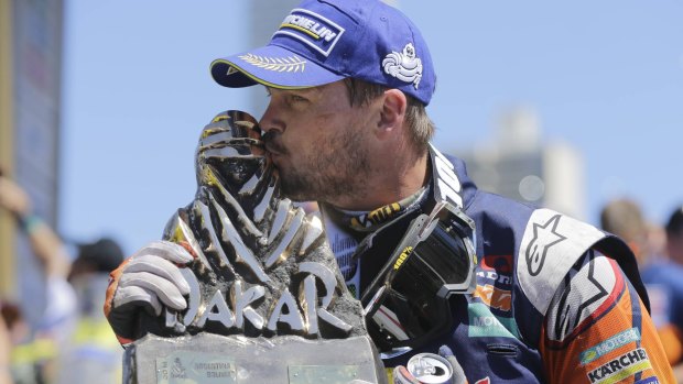 Sealed with a kiss: Toby Price with his 2016 Dakar Rally winner's trophy in Rosario, Argentina.