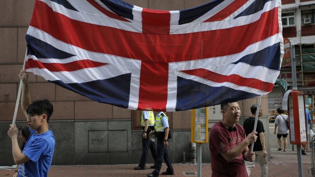 Protesters raise a Union Jack during a pro-democracy protest  on Wednesday on the 18th anniversary of the territory's handover from Britain to China.