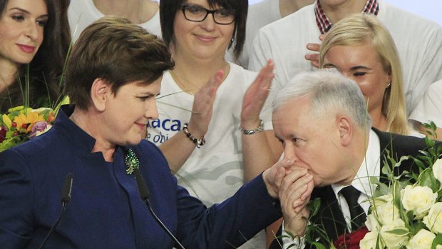 Conservative Law and Justice leader Jaroslaw Kaczynski  kisses the hand of his party's candidate for prime minister, Beata Szydlo, after early results show victory for the Eurosceptic side.