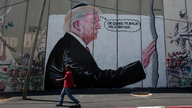 A mural resembles the work of elusive artist Banksy depicting US President Donald Trump wearing a Jewish skullcap on Israel's West Bank separation barrier in Bethlehem.