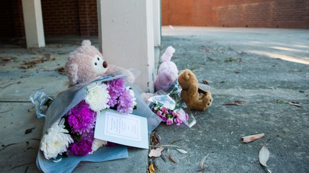 Foral tributes lay in front of the unit tower where a one-year-old girl died. 
