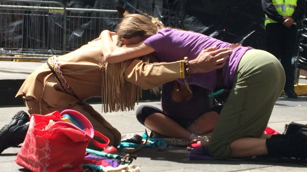 Native American shaman Walks The Wind and wife Joanne Proctor embrace following a sage burning ceremony for the victims of the Martin Place siege.