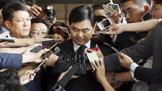 Senior South Korean prosecutor Jin Kyung-joon is surrounded by media upon his arrival for questioning at the Seoul Central District Prosecutors' Office in Seoul, South Korea.  