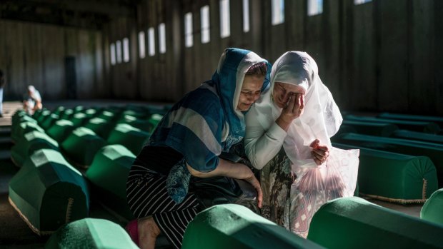 Relatives of people killed in the 1995 Srebrenica massacre mourn over their loved ones' coffins before burial in Potocari, Bosnia, in 2016.