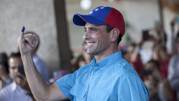 Opposition leader and Miranda State governor Henrique Capriles showing his finger after voting in Caracas.