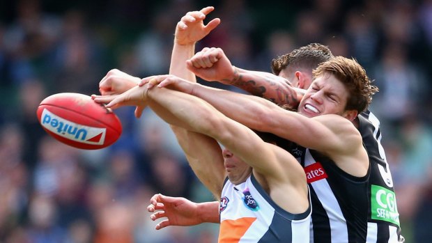 Taylor Adams and Jesse White of the Magpies spoil an attempt at a  mark by Toby Greene of the Giants.