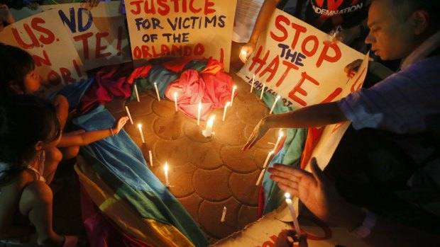 Filipinos light candles to pay tribute to the victims of the Orlando mass shooting as vigils are held across the world.