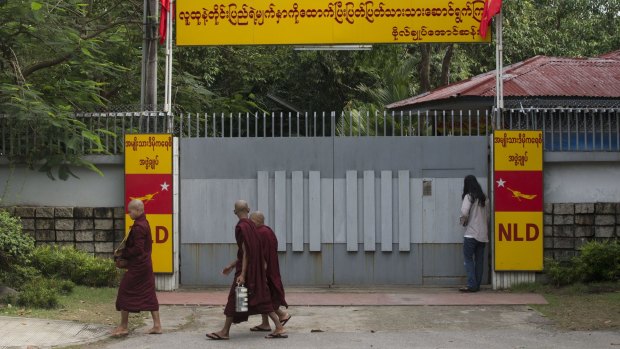 Buddhist monks walk past the front gate of Myanmar's opposition leader Aung San Suu Kyi's home in Yangon on Tuesday. 