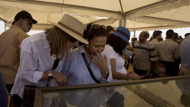 Tourists look at recently discovered artifacts at the Bent Pyramid during the opening.