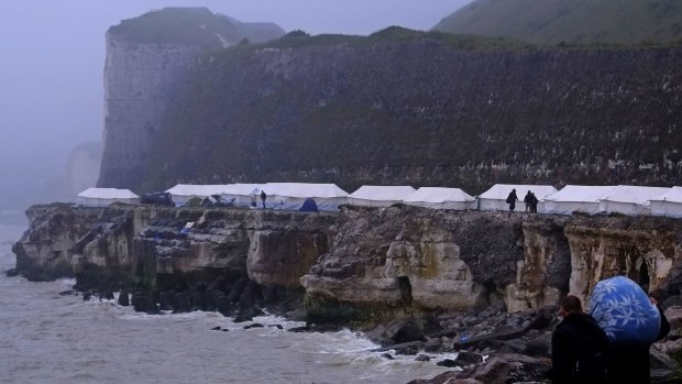 Migrants look out from a new makeshift camp perched along the storm-hit cliffs near Dieppe, northern France, overlooking the English Channel, last week.  A group of around 150 Albanian migrants have set up a tented encampment hoping to cross to the UK.