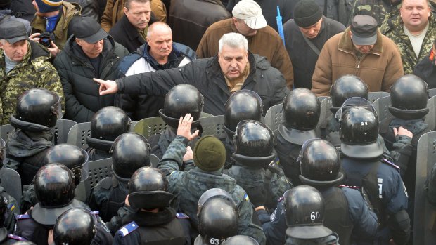 A protester argues with police in front of Ukrainian Parliament.