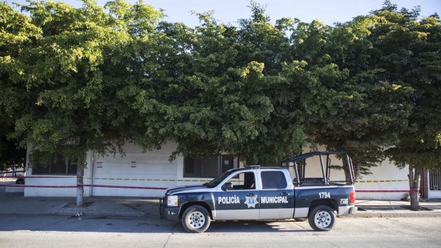 A police truck sits parked outside the house where marines engaged in a gun battle during the search for Mexican drug lord Joaquin Guzman Loera, in Los Mochis, Mexico, on Sunday.