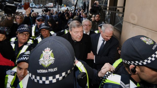 Cardinal George Pell arrives at Melbourne Magistrates Court surrounded by police, and his lawyers.