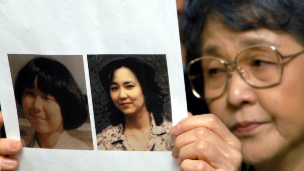 In this 2002 photo, Megumi Yokota's mother Sakie shows journalists a picture of her daughter a month before her abduction and a picture purportedly of Megumi as an adult supplied by North Korean authorities. According to Pyongyang, Megumi committed suicide at a mental hospital in 1993.