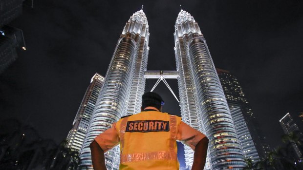 A security officer stands guard in front of the Twin Towers in Kuala Lumpur.