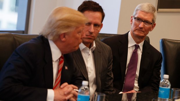 Apple CEO Tim Cook, right, and PayPal founder Peter Thiel, centre, listen as Donald Trump speaks during a meeting with technology industry leaders at Trump Tower in New York in December.
