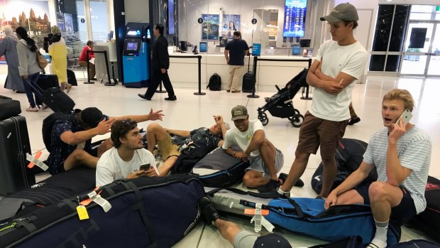 A group of surfers from Sydney wait for updates on their cancelled flight to Sumatra via Denpasar.