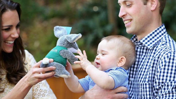 Prince William holds Prince George as his mother Catherine hands him a toy bilby on their visit to Australia last year.
