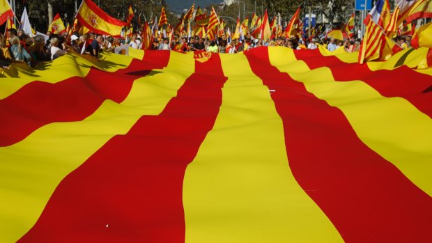 Nationalist activists protest with a giant Catalan flag during a mass rally against Catalonia's declaration of independence.