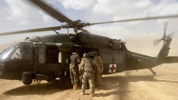 Three wounded soldiers board a US Aero Medical Evacuation helicopter in Afghanistan. A soldier wounded by an IED has received a penis transplant.