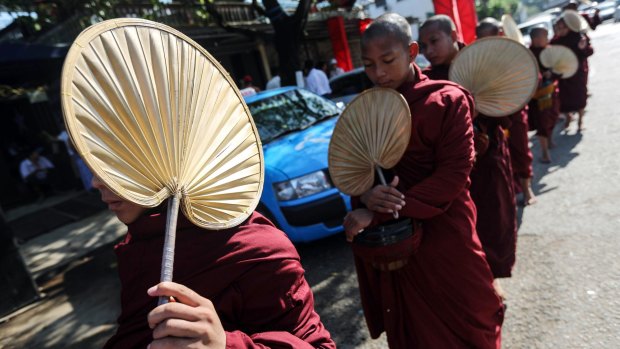 Buddhist monks walk past the National League for Democracy (NLD) headquarters on Monday. 
