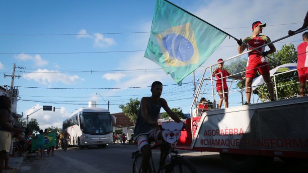 A man waves a Brazilian flag along the Olympic torch route as it passes through Recife, Brazil, this week.