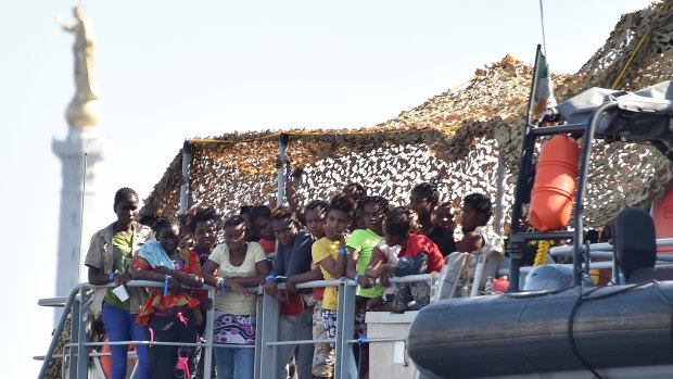 Migrants wait to disembark from the Irish Navy vessel LE Niamh at the Messina harbour in Sicily, Italy, on Monday.