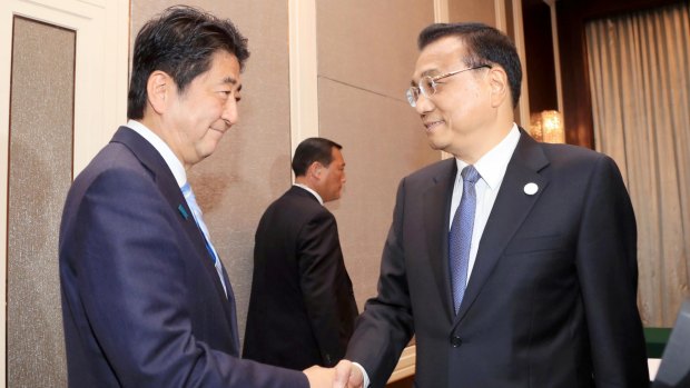 Chinese Premier Li Keqiang, right, and Japanese Prime Minister Shinzo Abe shake hands during a bilateral meeting held on Friday.